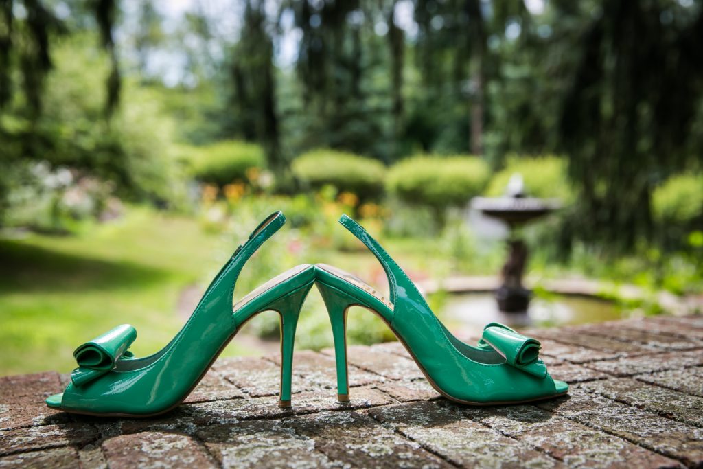 Green high heels on brick wall at a Round Hill House wedding