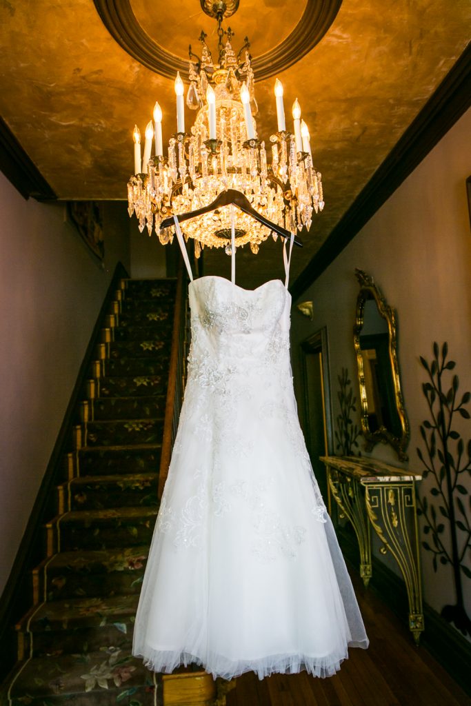 Wedding dress hanging from chandelier at a Round Hill House wedding