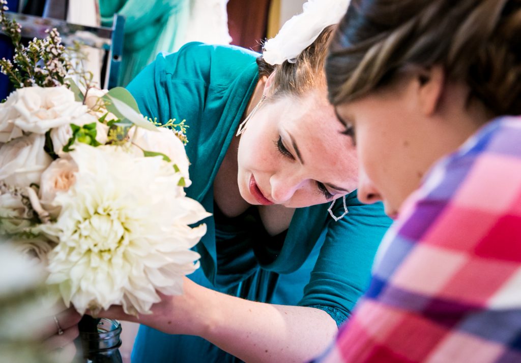 Close up on two women adjusting flower bouquet