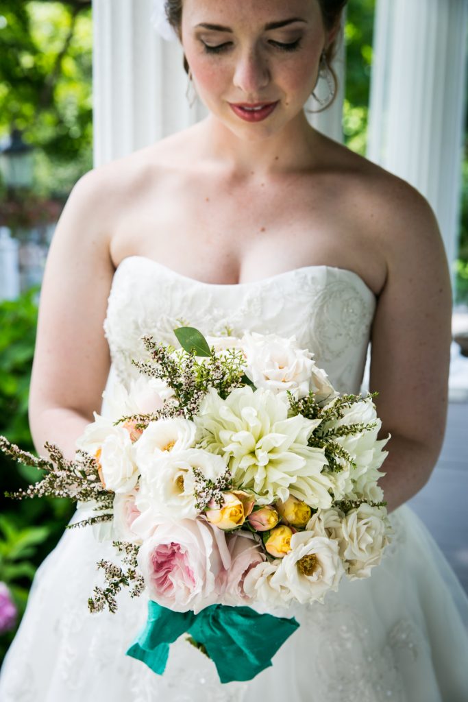 Bride looking down at flower bouquet at a Round Hill House wedding