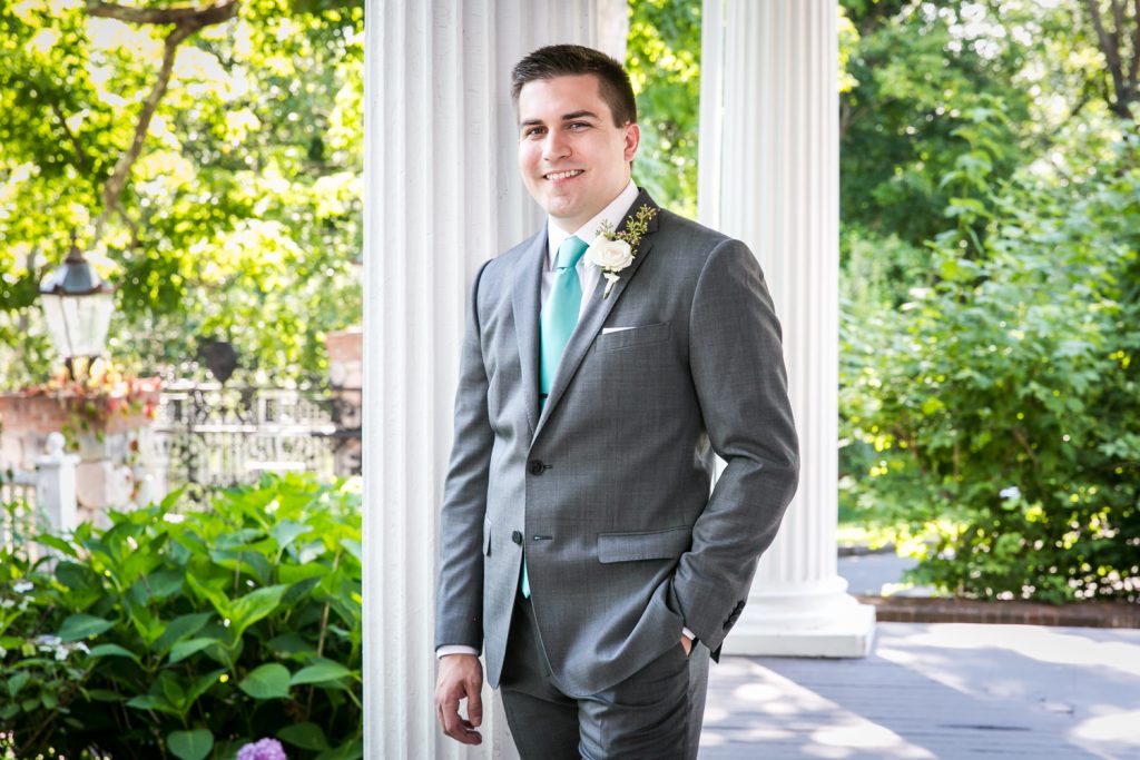 Groom posing against columns at a Round Hill House wedding