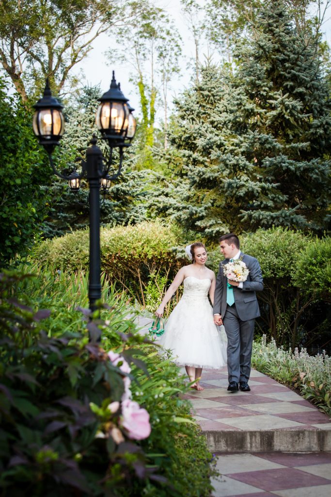 Bride and groom walking down garden pathway at a Round Hill House wedding