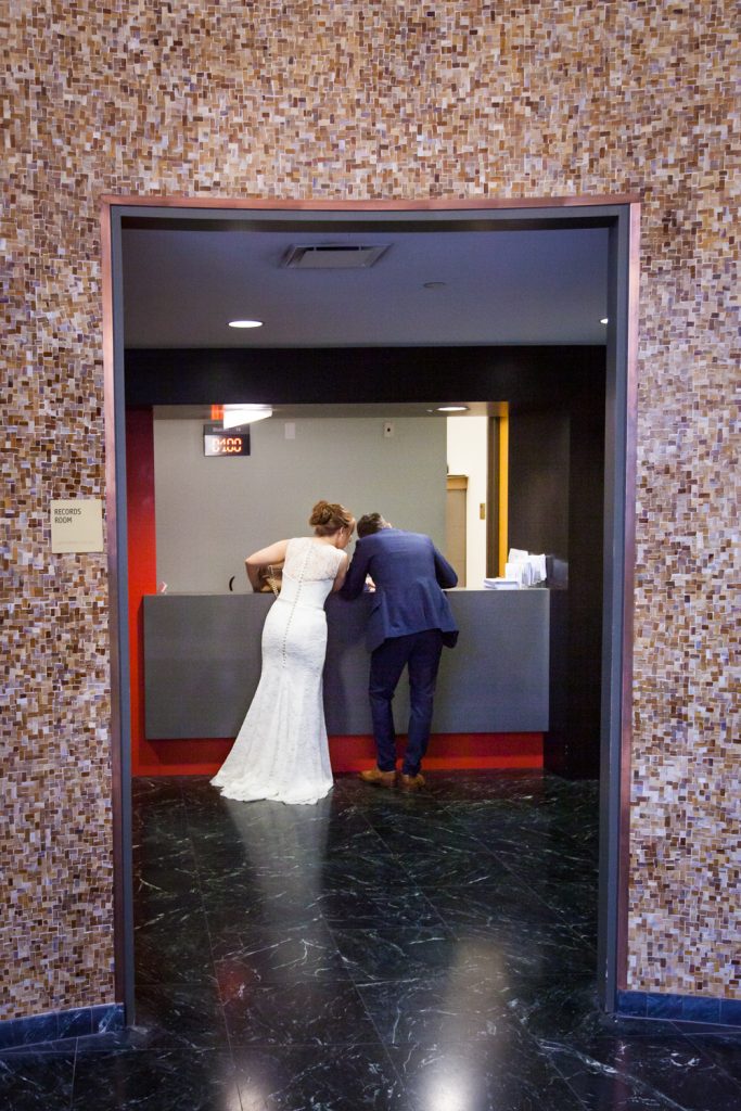 NYC City Hall wedding photos of bride and groom at City Clerks Office desk