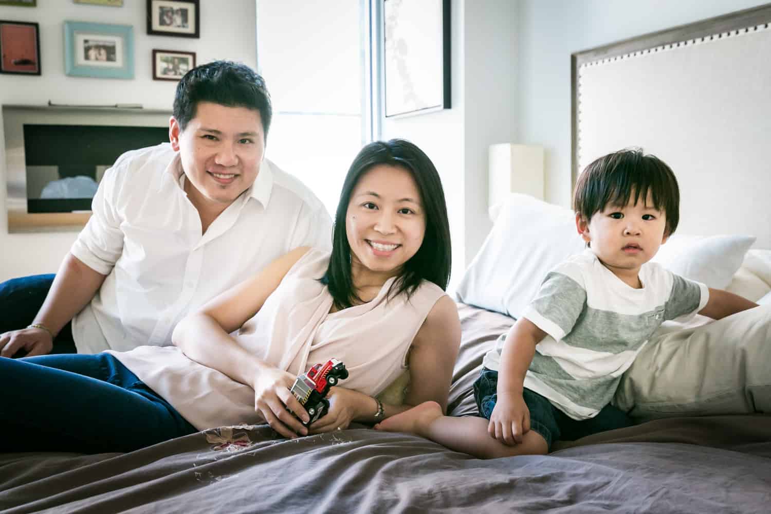 Manhattan family portrait of parents and child laying on bed