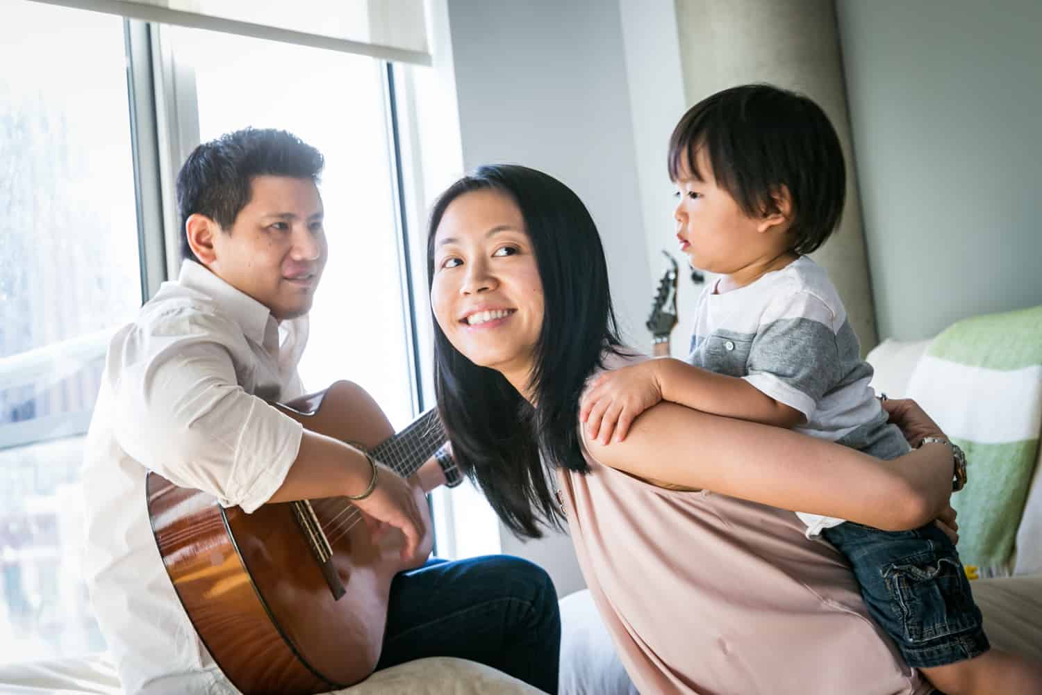 Manhattan family portrait of parents and child playing guitar