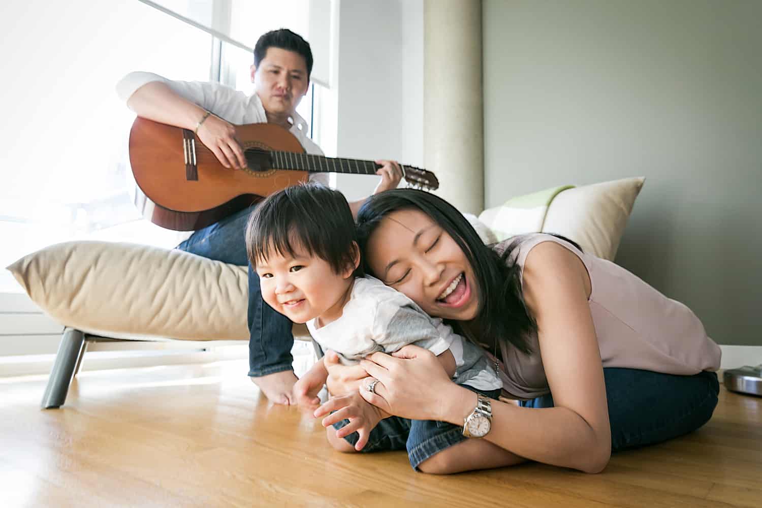 Manhattan family portrait of parents and child playing guitar