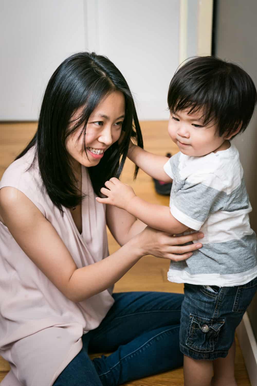 Asian American mother tickling child