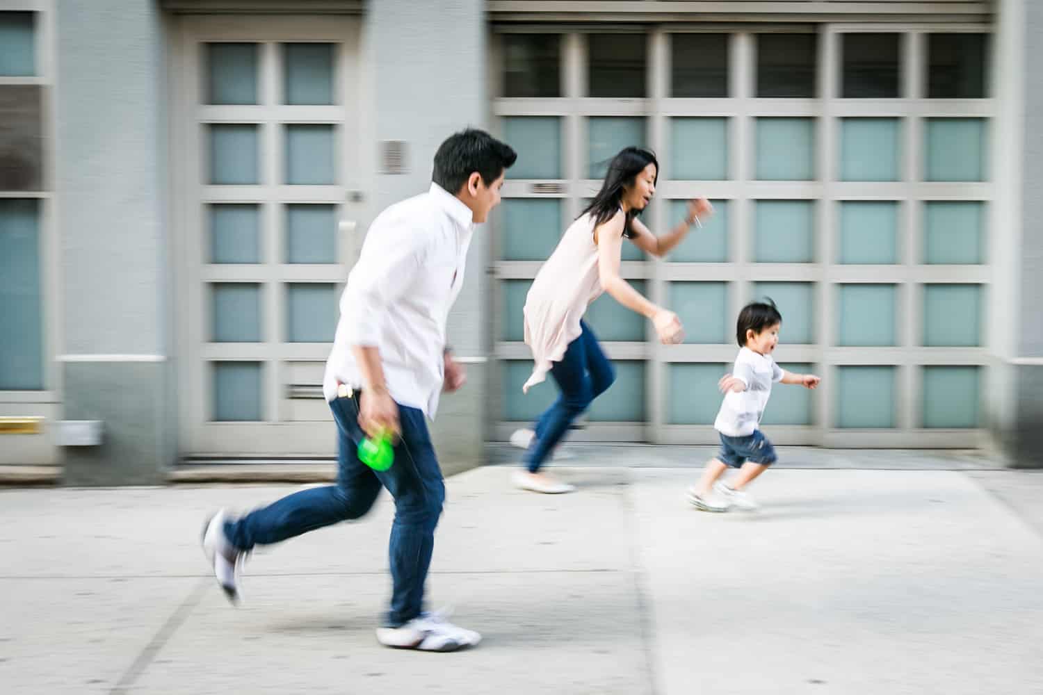 Parents running after little boy on Manhattan sidewalk