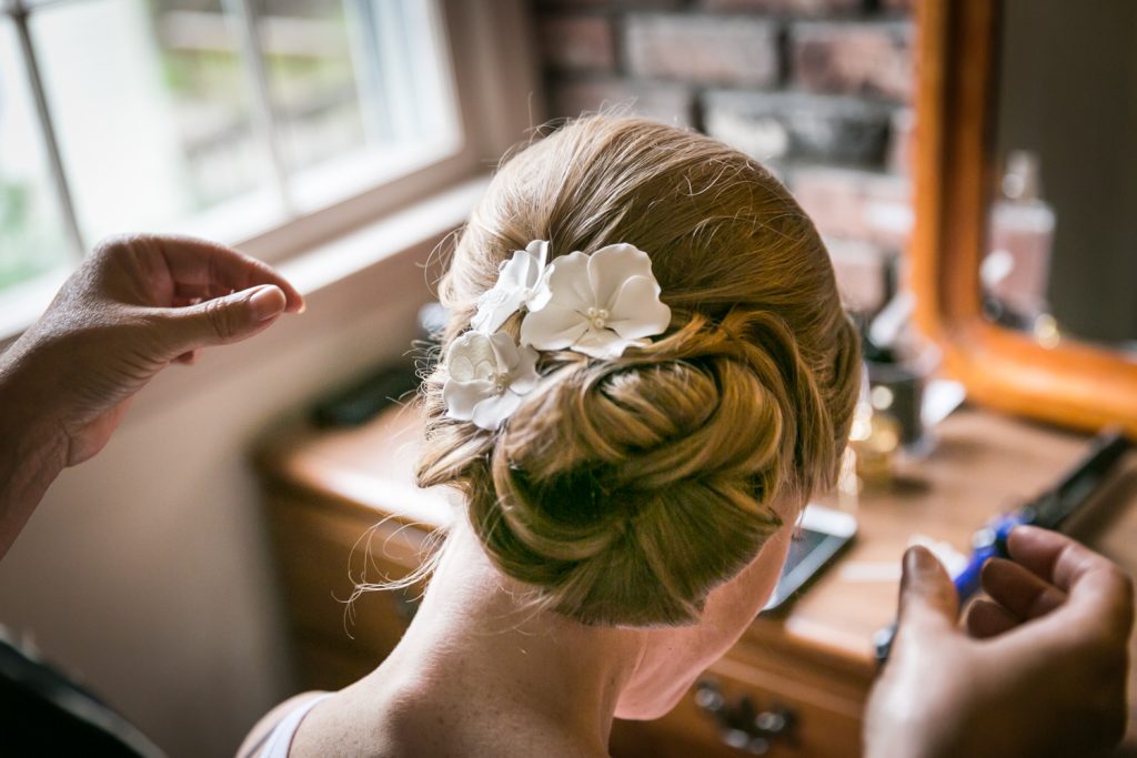 Close up on woman's hair in bun with flower barrette