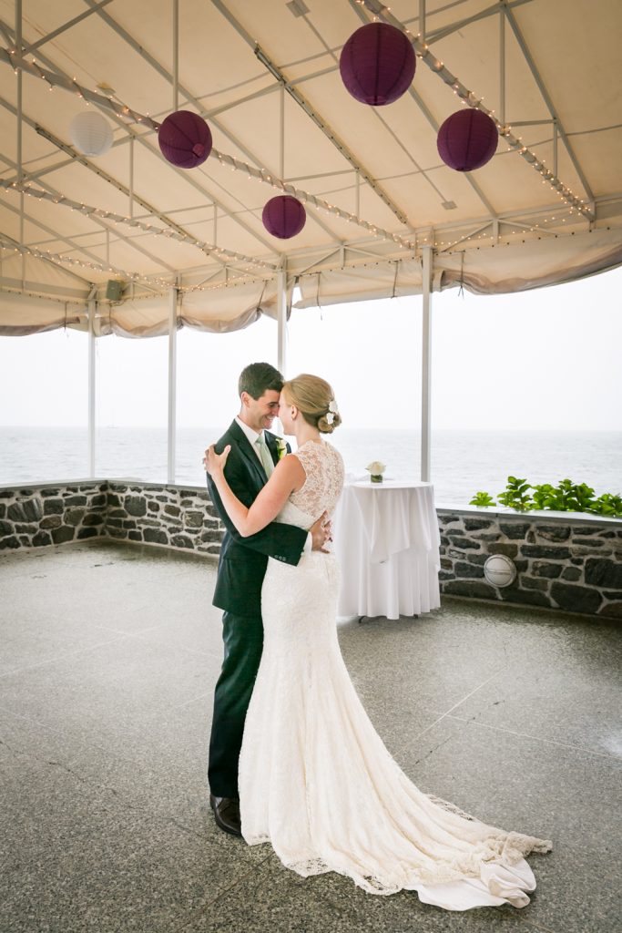 Bride and groom under tent hugging at an American Yacht Club wedding