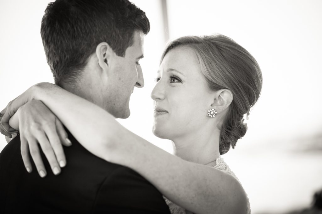 Black and white portrait of bride and groom hugging at an American Yacht Club wedding