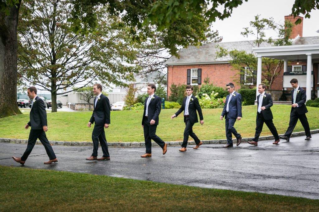 Groom and groomsmen walking in line to ceremony at an American Yacht Club wedding
