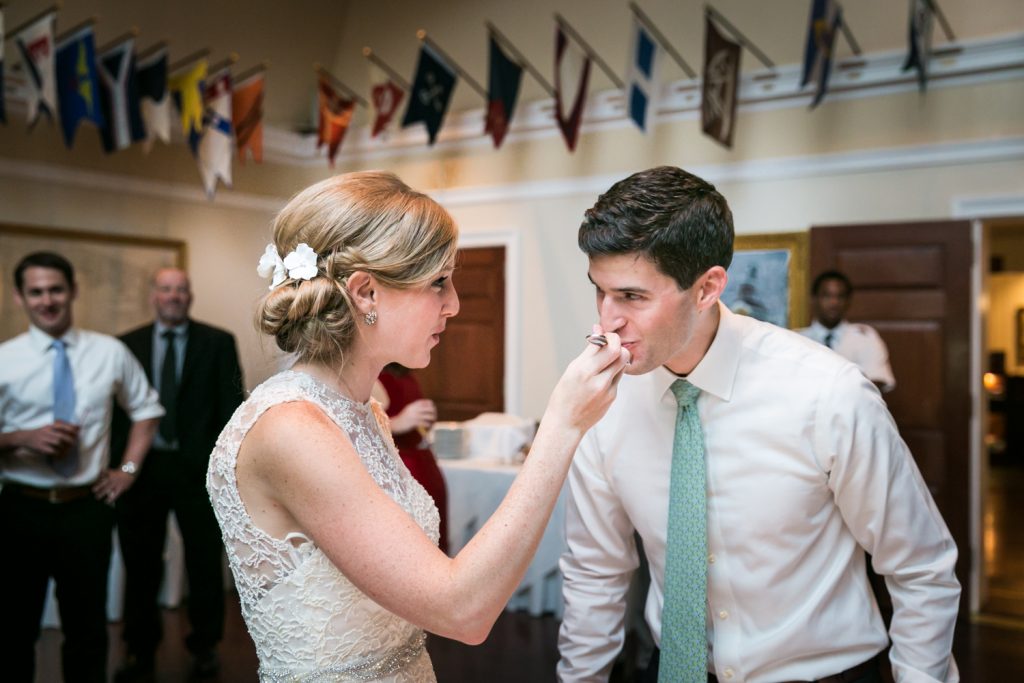 Bride feeding cake to groom at an American Yacht Club wedding