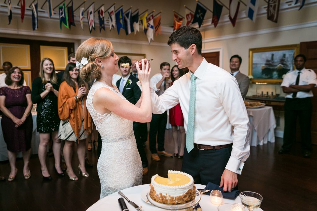 Groom about to feed wedding cake to bride