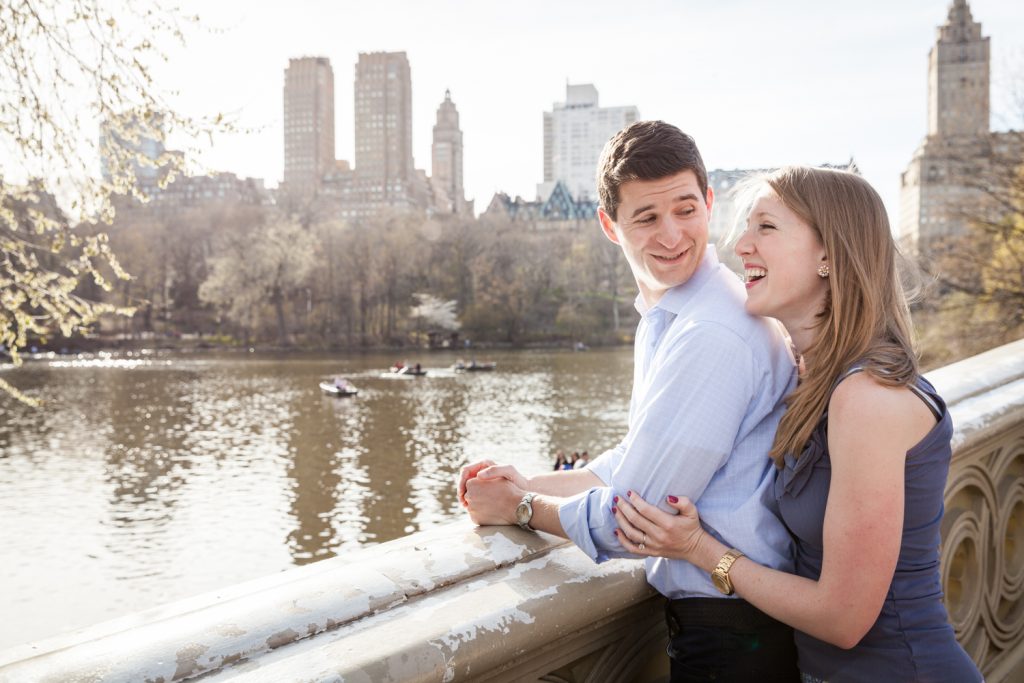 Man and woman looking at each other across from Central Park lake during a Central Park engagement session