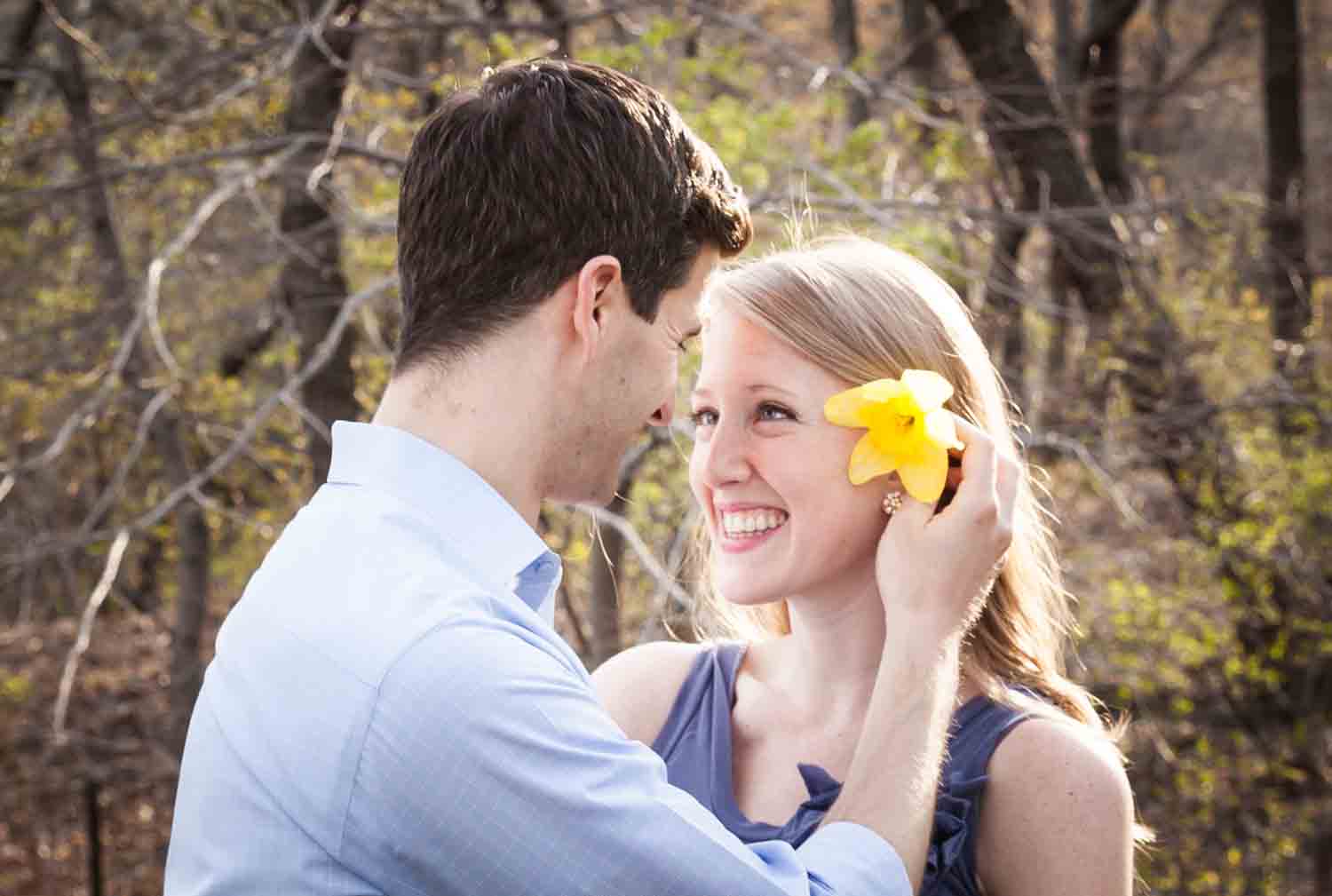 Man putting daffodil in woman's hair