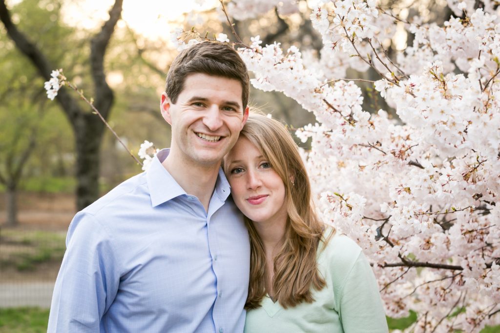 Couple in front of cherry blossom trees in Central Park