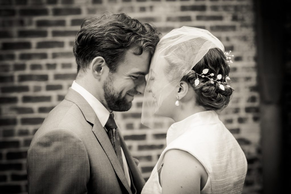 Black and white photo of bride and groom touching foreheads