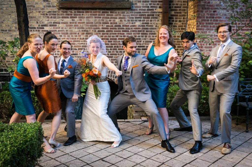 Bridal party in church patio doing martial arts pose