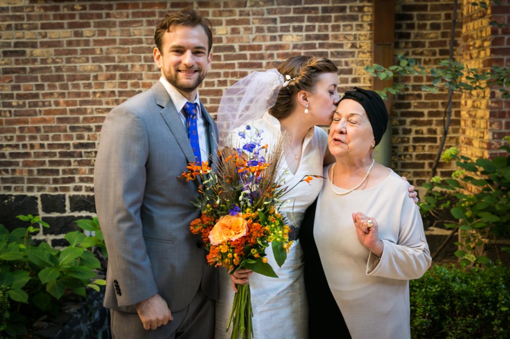 Bride kissing grandmother with groom 