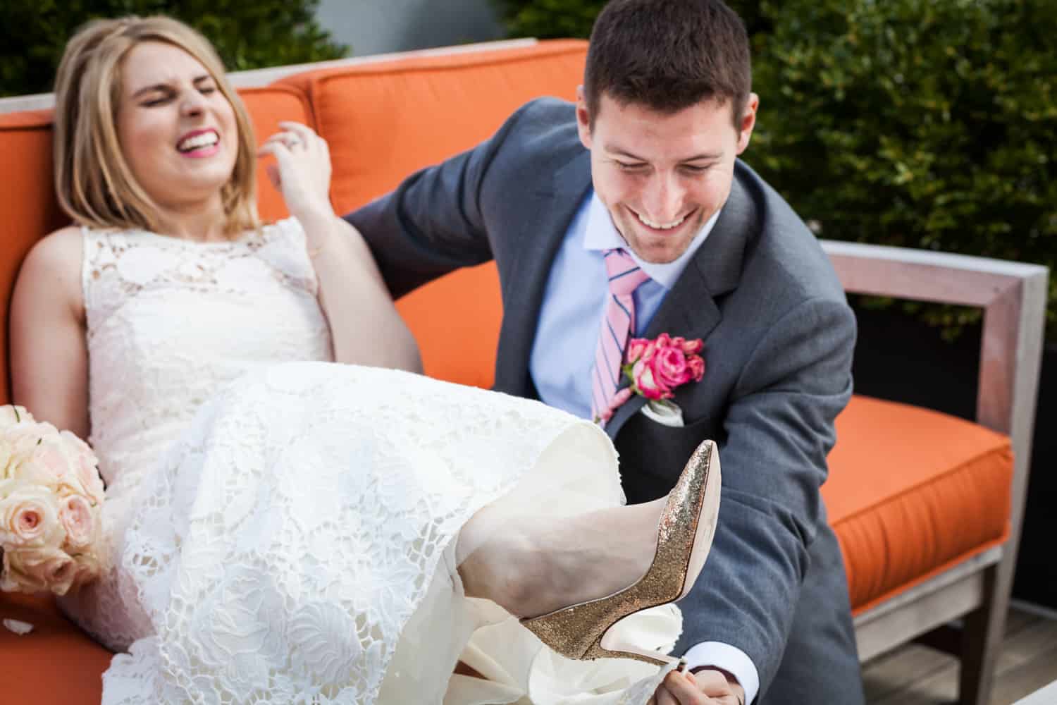 Groom getting train of bride's dress unhooked from her heel