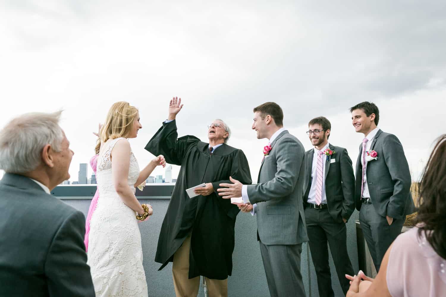 Officiant with hand in air during rooftop wedding ceremony