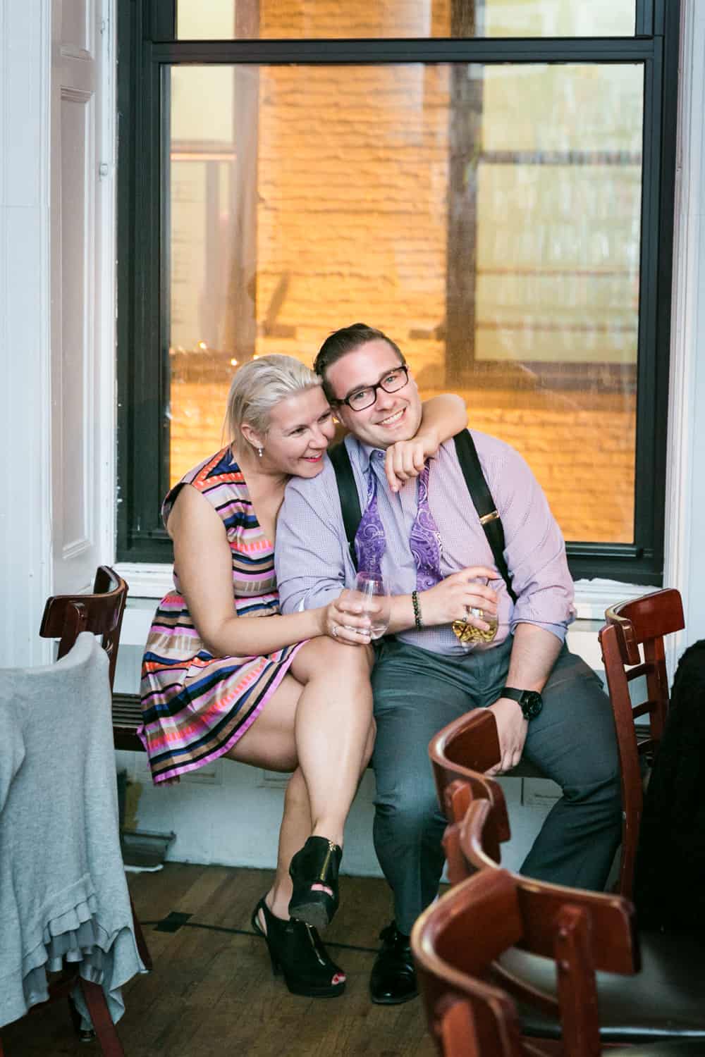 Couple hugging on windowsill at a Housing Works wedding