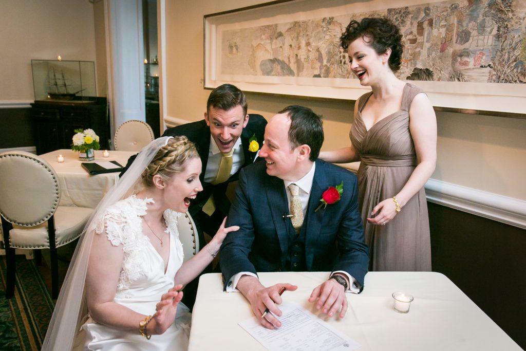 Bridal party laughing after signing wedding license