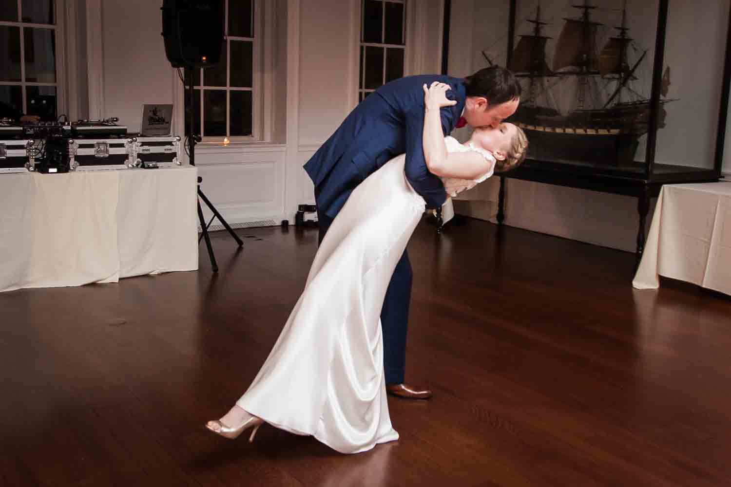 Groom dipping and kissing bride during first dance