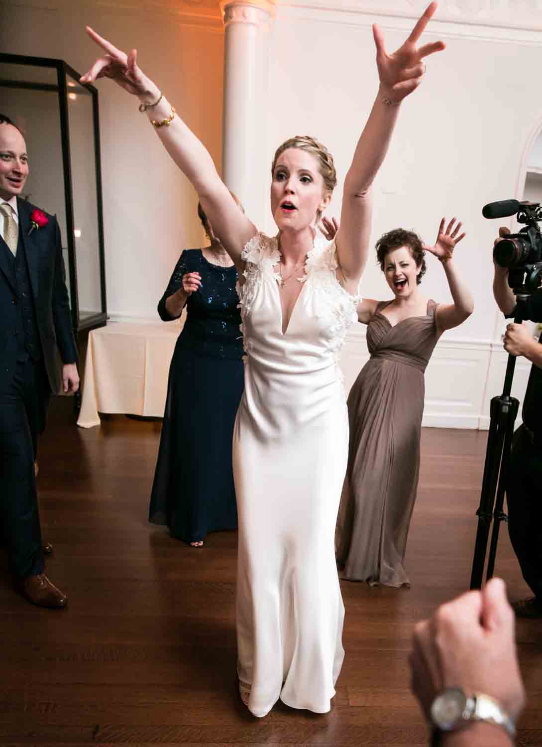 Bride dancing with arms outstretched at an India House wedding