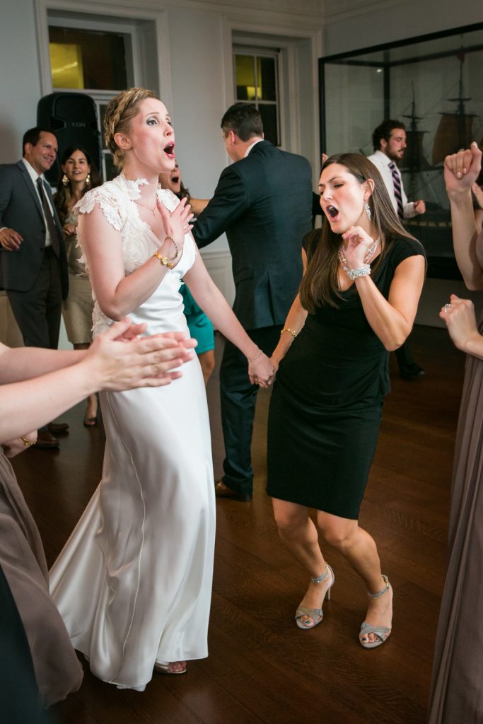Bride holding hands with female guest and singing