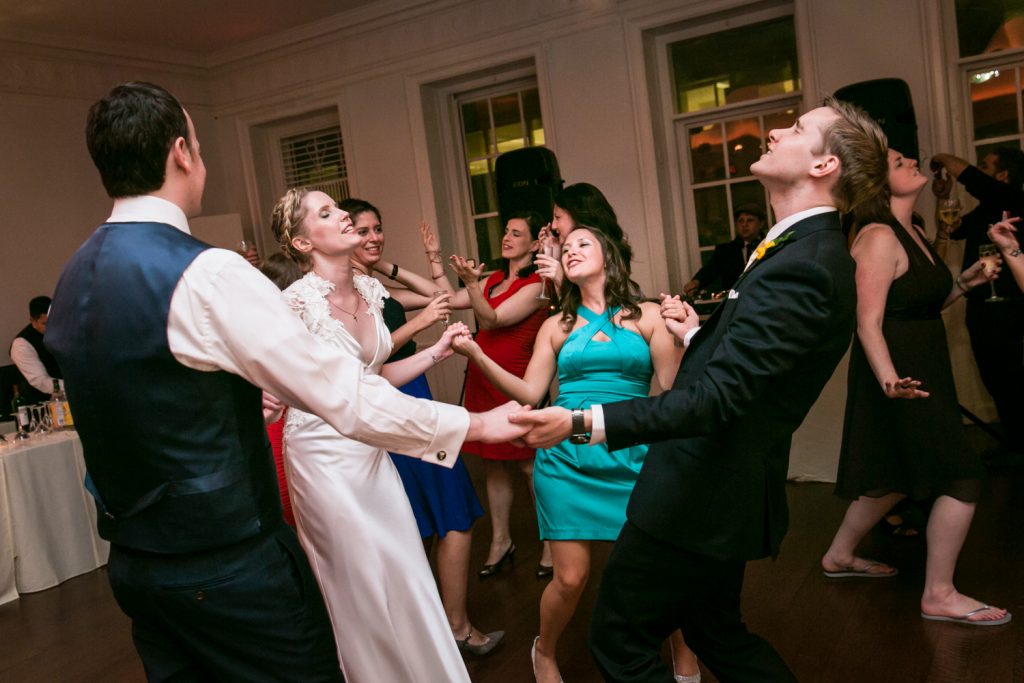 Bride and groom dancing with guests in a circle