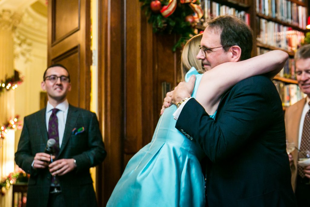 Father of the groom hugging woman in blue dress at a Lotos Club engagement party