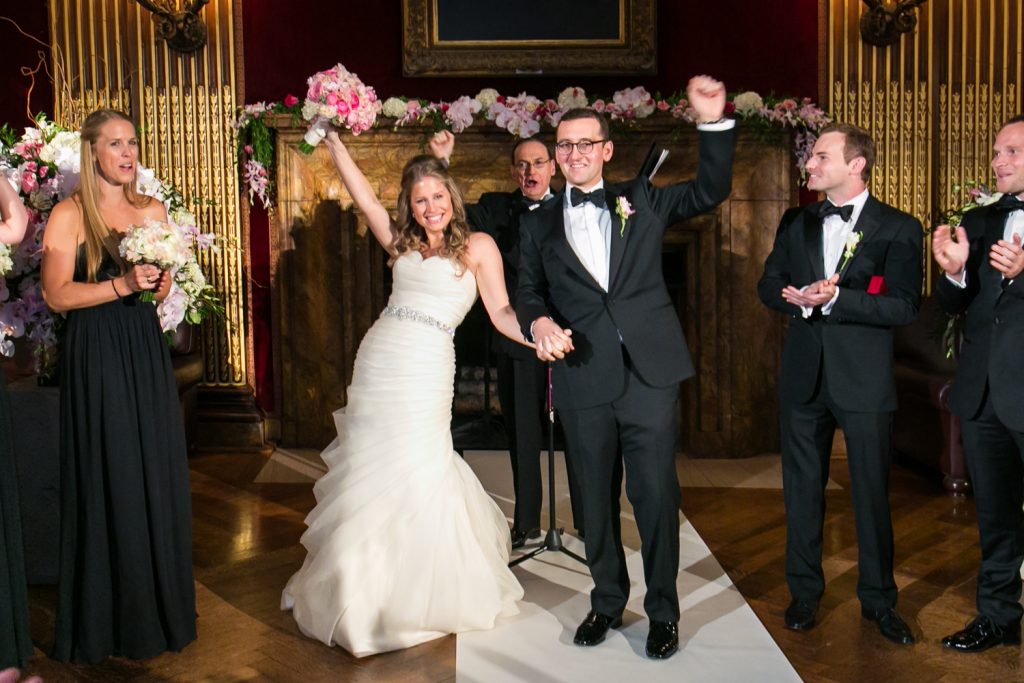 Bride and groom cheering after getting married at a University Club wedding
