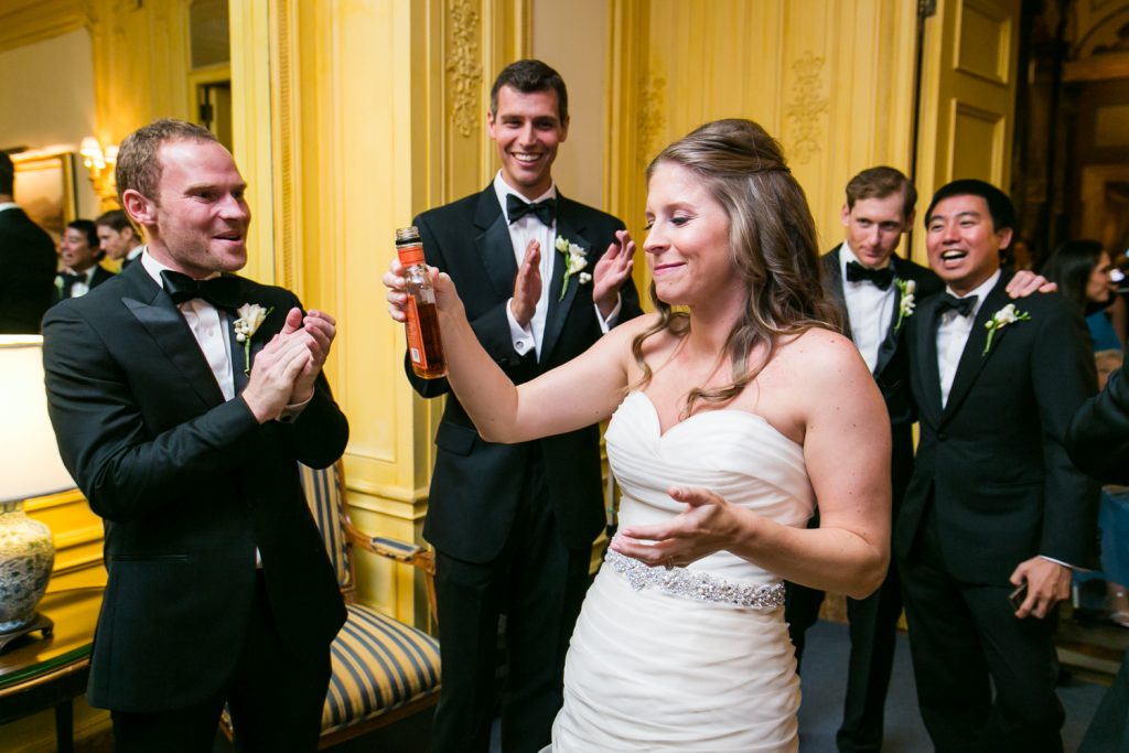 Bride taking a drink of whiskey after a University Club wedding