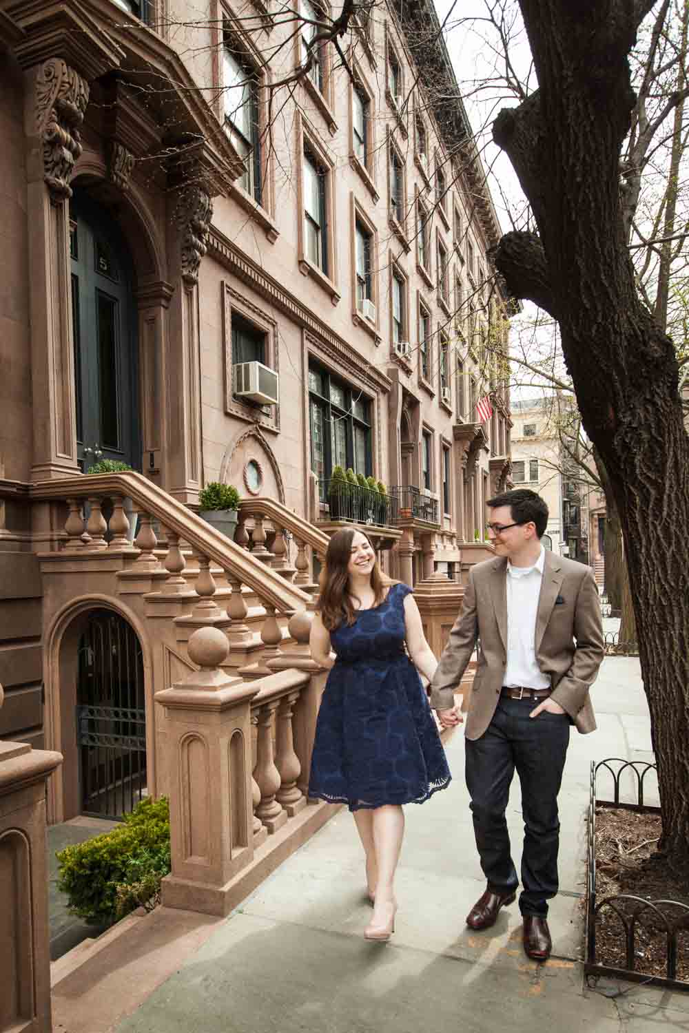 Brooklyn Promenade engagement photos of couple walking past brownstones