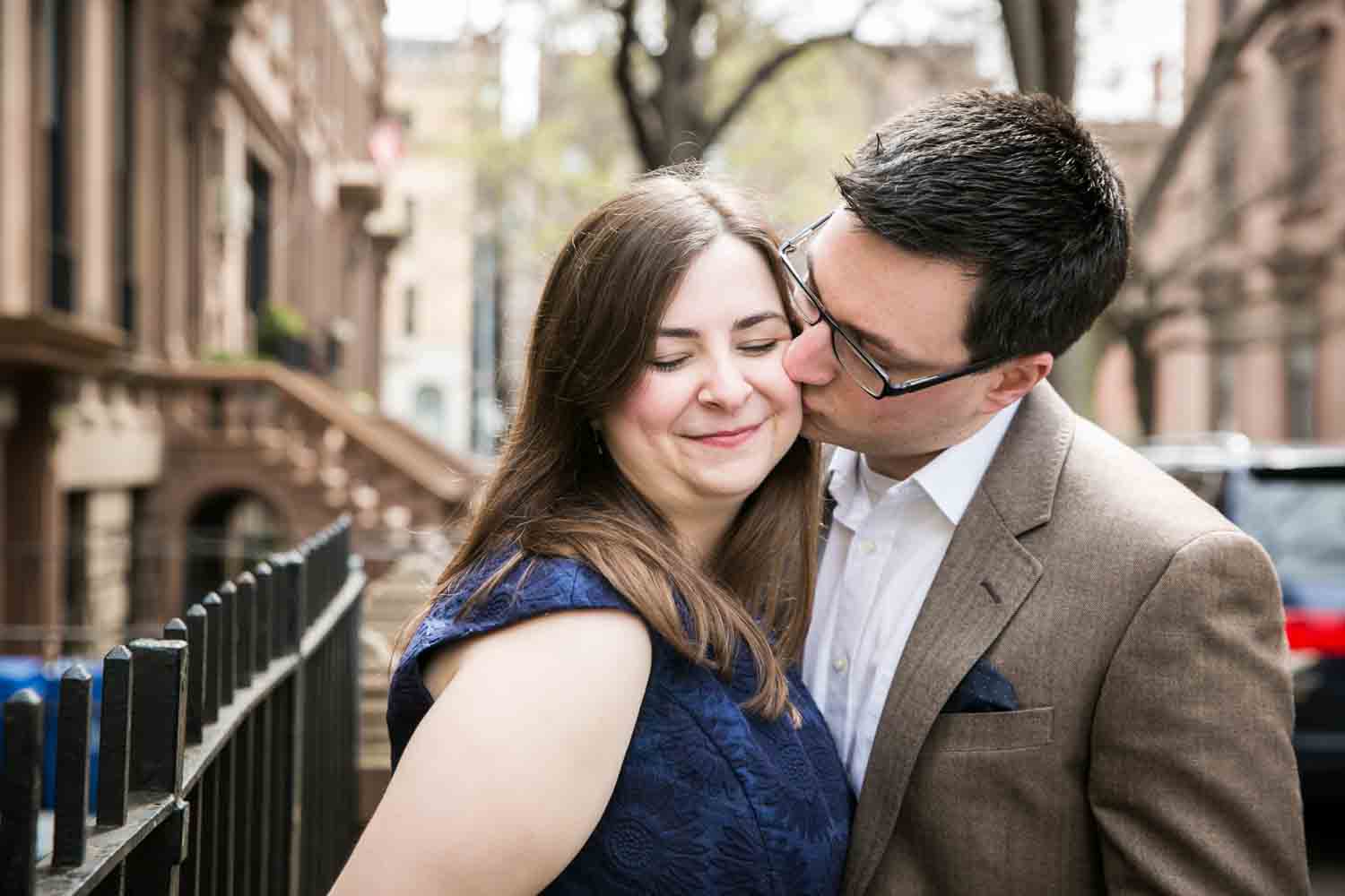 Brooklyn Promenade engagement photos of man kissing woman on the cheek