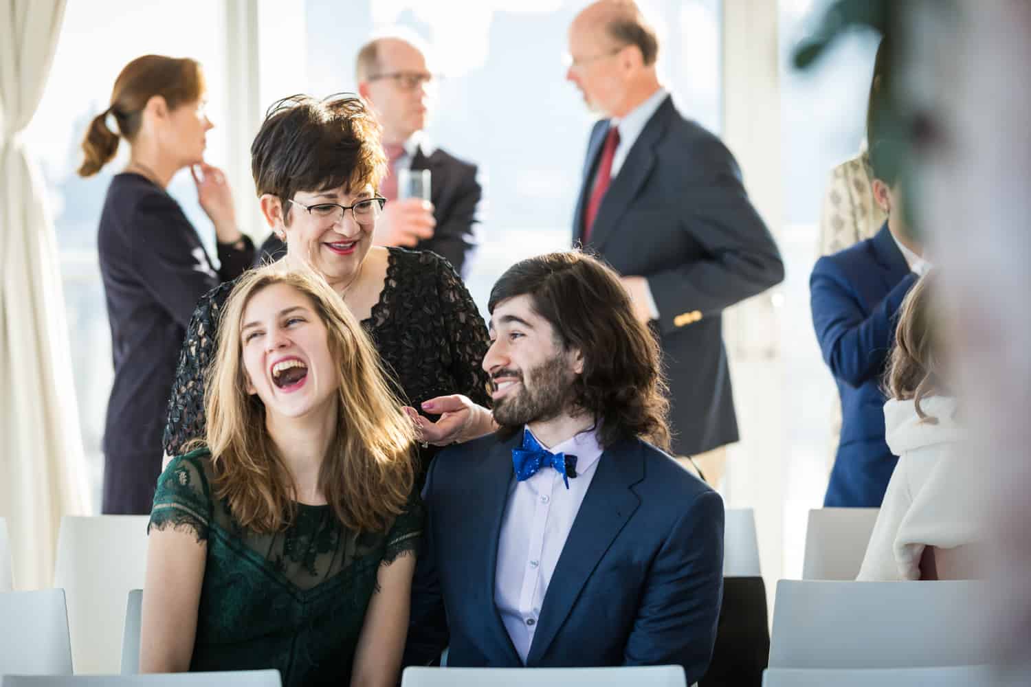 Guest laughing during cocktail hour for an article on what is wedding photojournalism