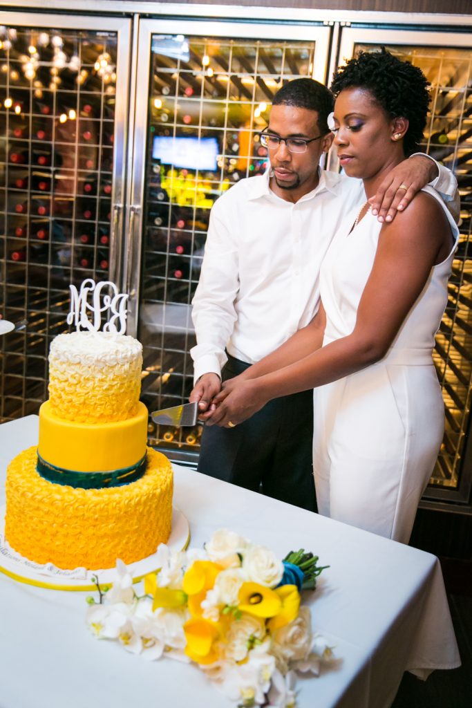 Bride and groom cutting yellow cake at a Flushing Meadows Corona Park wedding