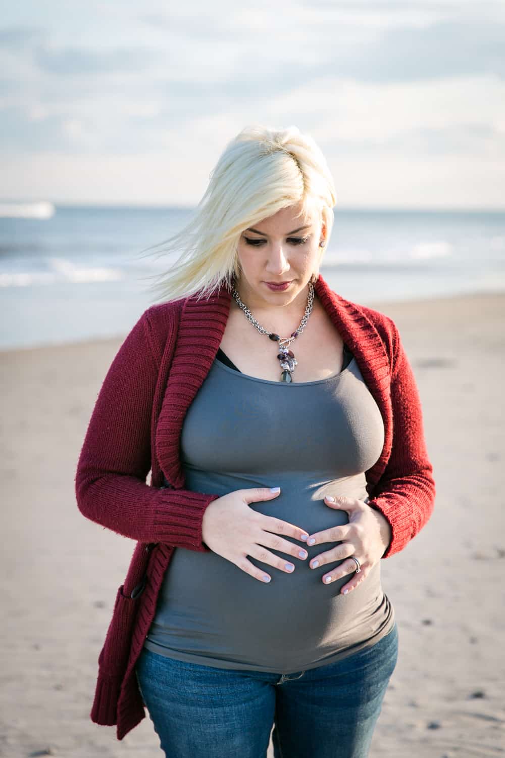 Pregnant blond woman on beach for an article on how to prepare for a maternity photo shoot