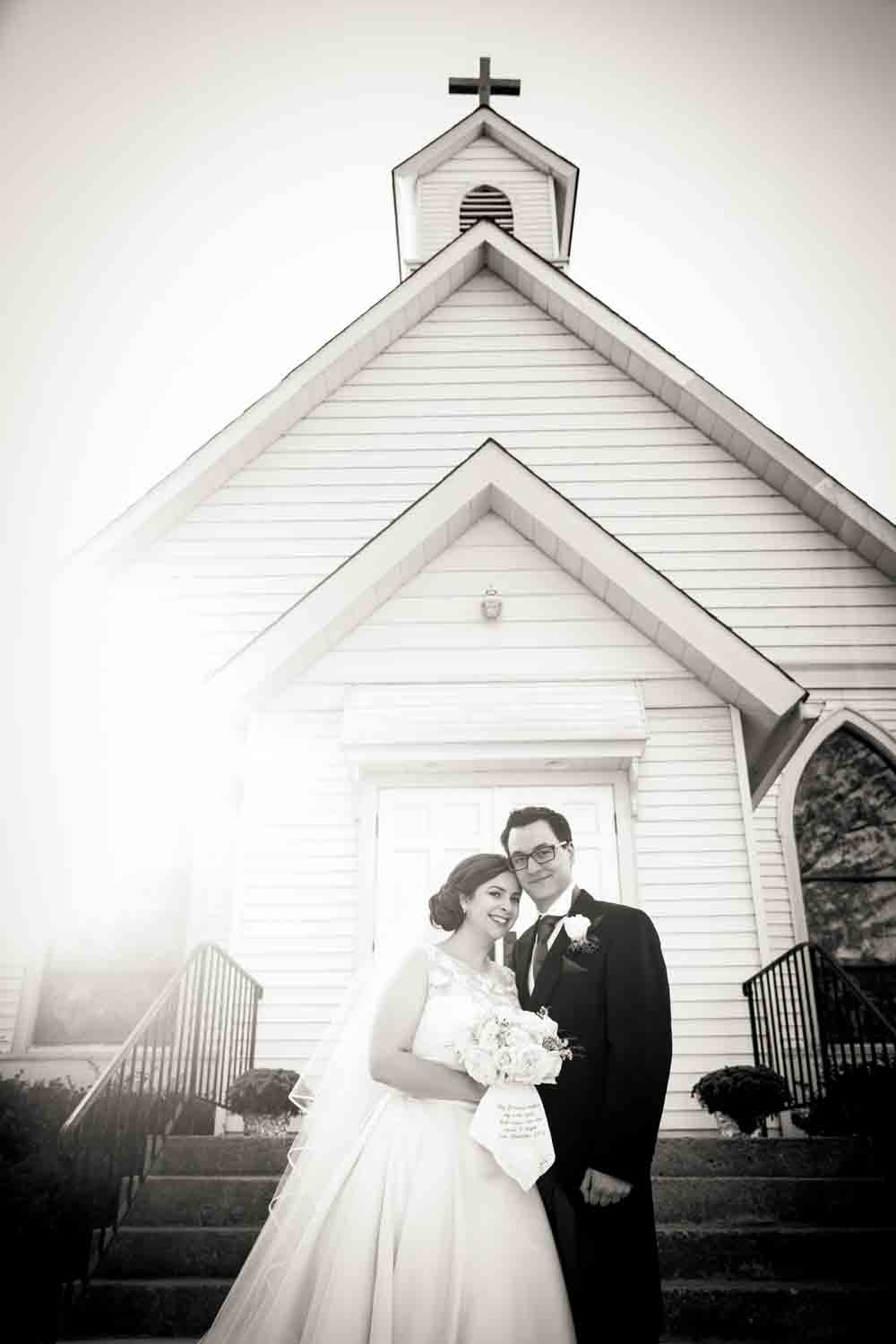 Black and white photo of bride and groom outside St. James Church in Pennington, NJ