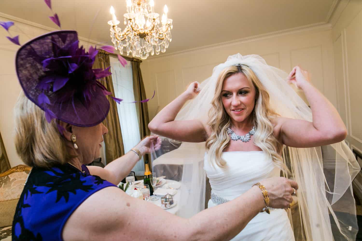 Mother helping bride adjust her veil