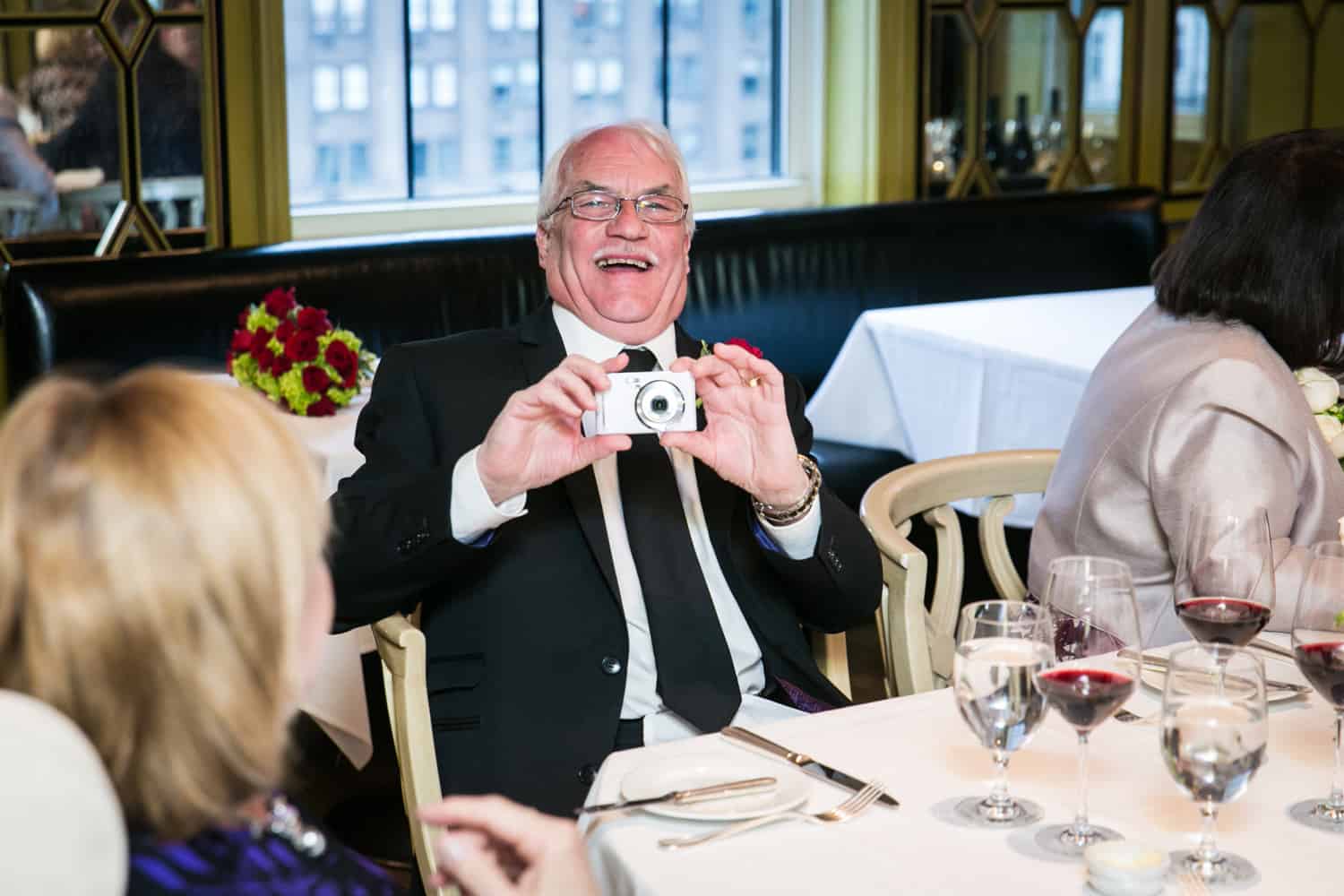 Older gentleman taking photo at a Bergdorf Goodman wedding reception