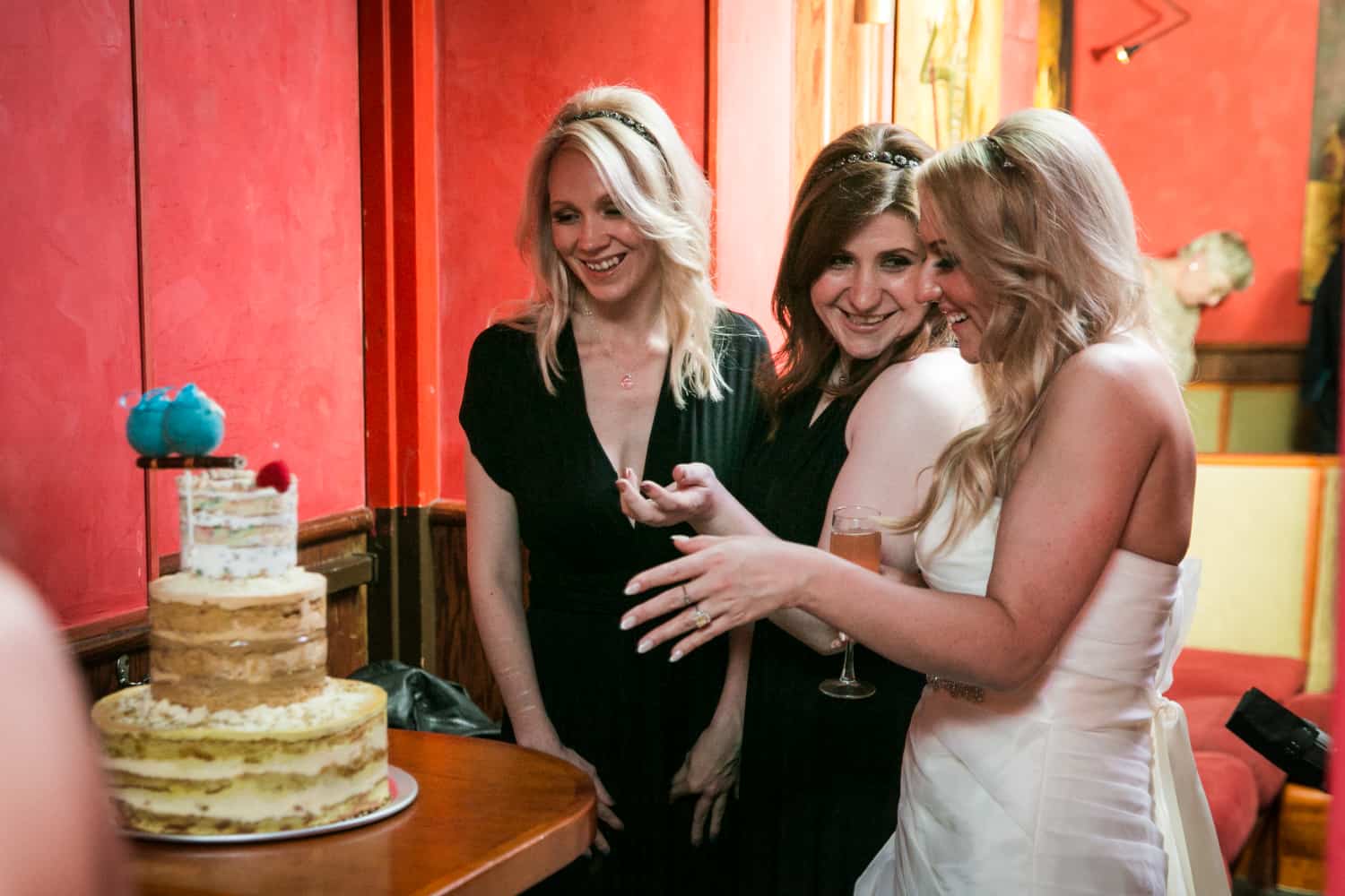 Bride showing off cake to female guests at a Bergdorf Goodman wedding reception