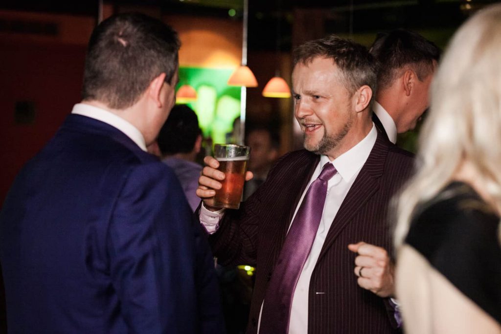 Male guest enjoying a glass of beer at a Bergdorf Goodman wedding reception
