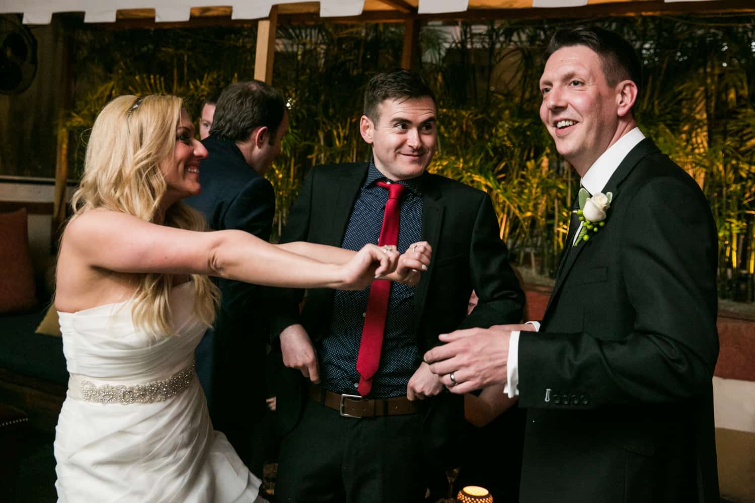 Bride dancing with groom and guest at a Bergdorf Goodman wedding reception