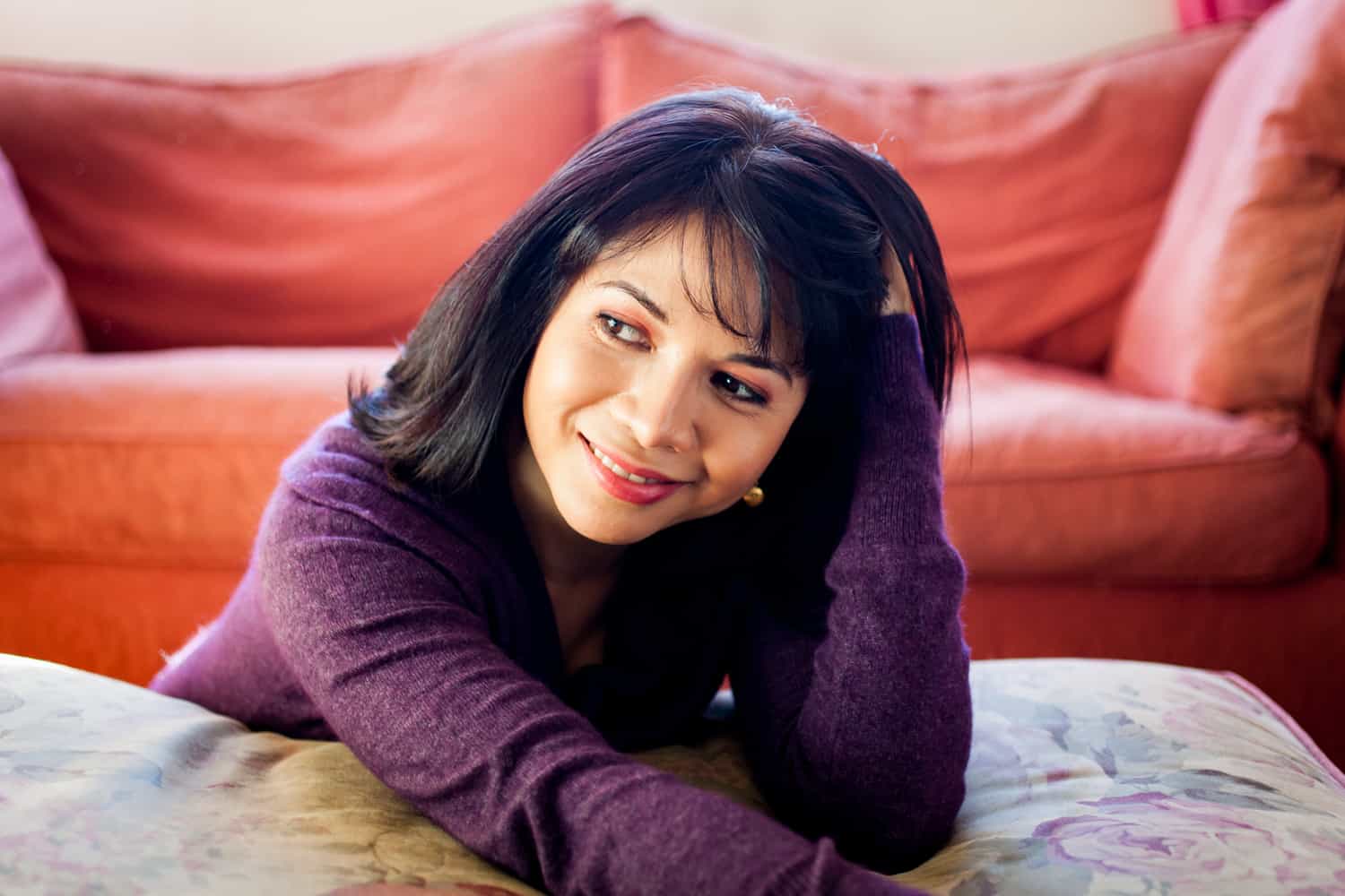 Woman with short black hair wearing purple sweater for an article on how to look slimmer in photos