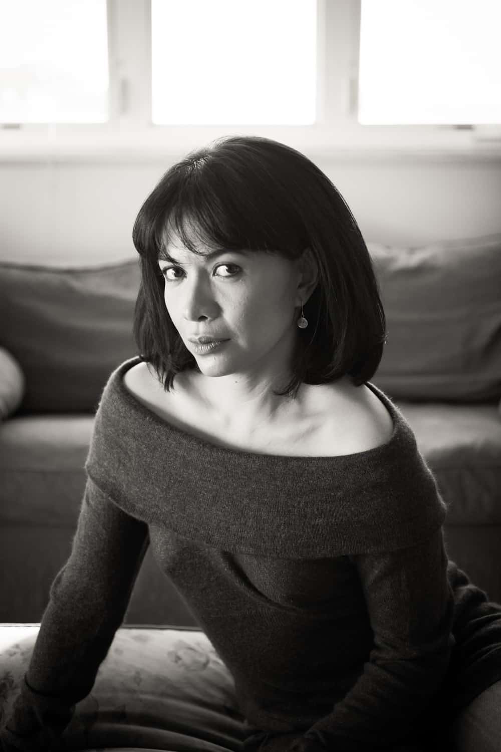 Black and white photo of woman with short black hair wearing off-shoulder sweater