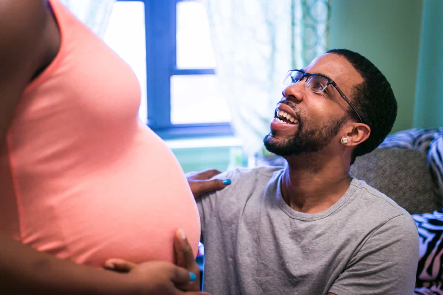 Father-to-be looking up in nursery by Queens maternity photographer