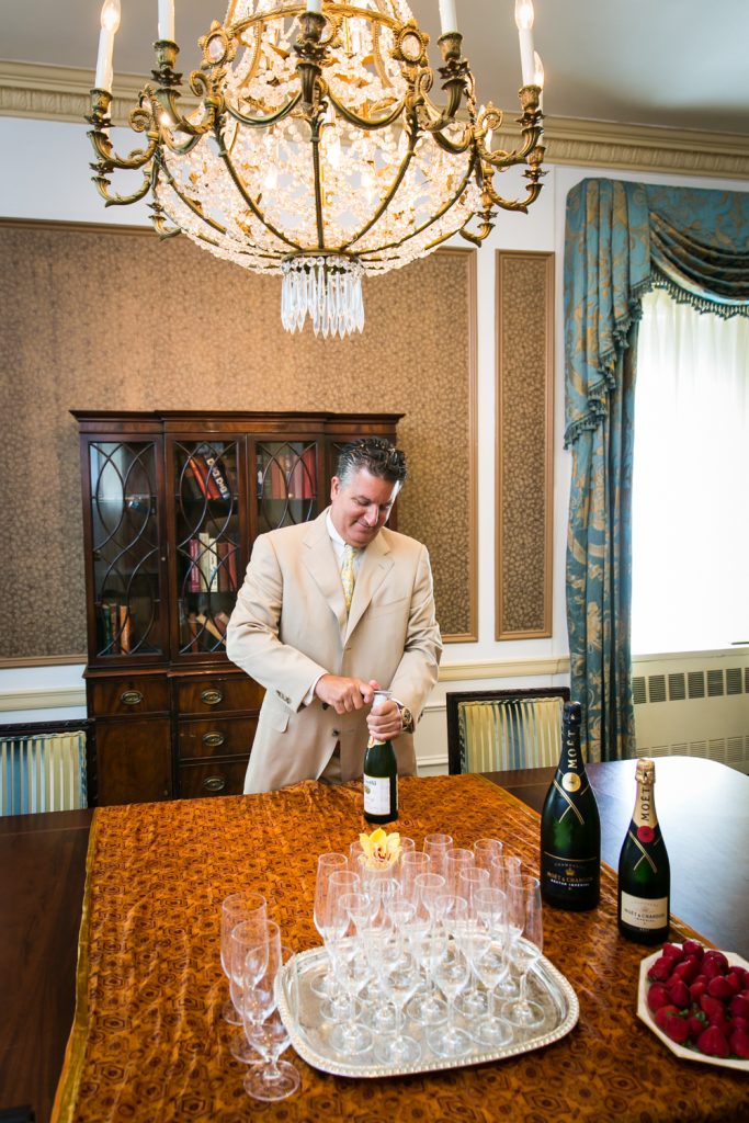 Man opening bottle of champagne at a Waldorf Astoria wedding